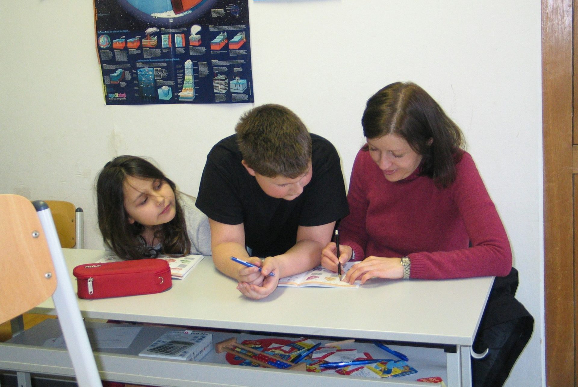 eine Gruppe von Menschen sitzt an einem Tisch und lernt